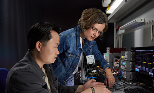 Ruth trabalha com tecnologia de chips com um colega na bancada do laboratório.