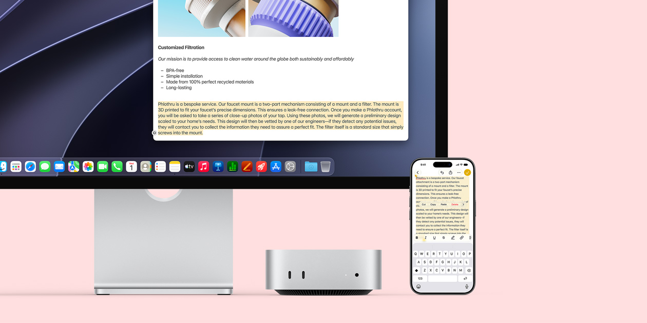 Pohled zepředu na Mac mini zasunutý pod Studio Displayem, napravo od zařízení a displeje je položený iPhone. Na displeji je vybraný text a nad ním jsou vidět příkazy Vyjmout, Kopírovat, Vložit a Vyplnit automaticky. Zvýrazněný text na displeji se shoduje s textem vybraným na iPhonu, aby byla vidět možnost použití Univerzální schránky.