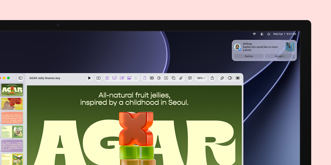 Ecrã do Studio Display a mostrar uma apresentação do Keynote sobre gomas de fruta, com uma notificação no canto superior direito a indicar o pedido de outra pessoa para partilhar uma fotografia