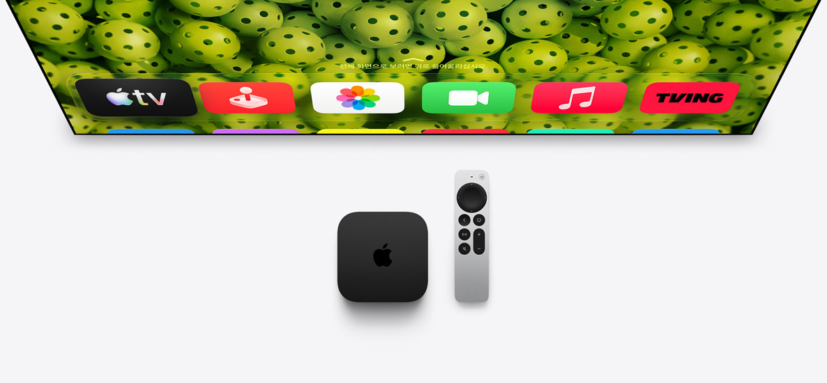 Apple TV 4K와 Siri Remote가 TV 화면 아래에 있고, 화면에는 녹색 피클볼 배경 위로 홈 화면 맨 위 줄의 앱 아이콘이 표시된 모습