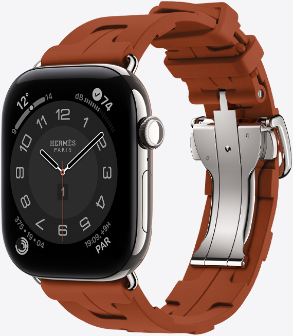 Apple Watch Hermès Series 12, carátula analógica Circulaire, (agujas de hora, minuto y segundo, complicaciones: Clima, Ruido, círculos de Actividad y hora de París), caja de titanio, color plata, parte lateral derecha, Digital Crown, botón lateral, con la correa Kilim Simple Tour, color Cuivre (café), fabricada con goma moldeada, diseño geométrico entrelazado, hebilla de metal color plata