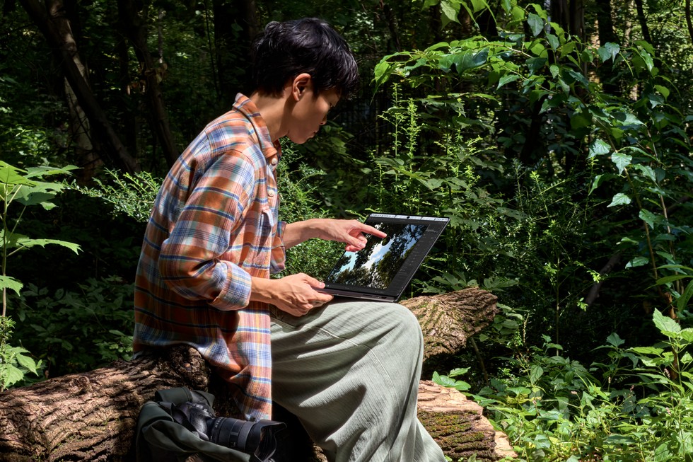 A user employs MacBook Pro with PROLED XDR Display outdoors in bright light.