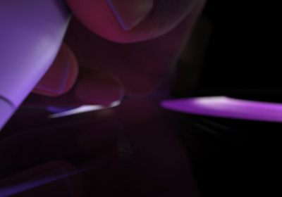 Потребител държи Apple Pencil Pro в позиция за писане. Върхът е натиснат върху дисплея, на който в яркозелено се очертават дебели щрихи.