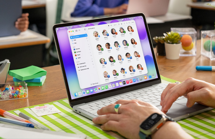 Una profesora sentada con un Mac abierto, la app Aula muestra la lista completa de estudiantes