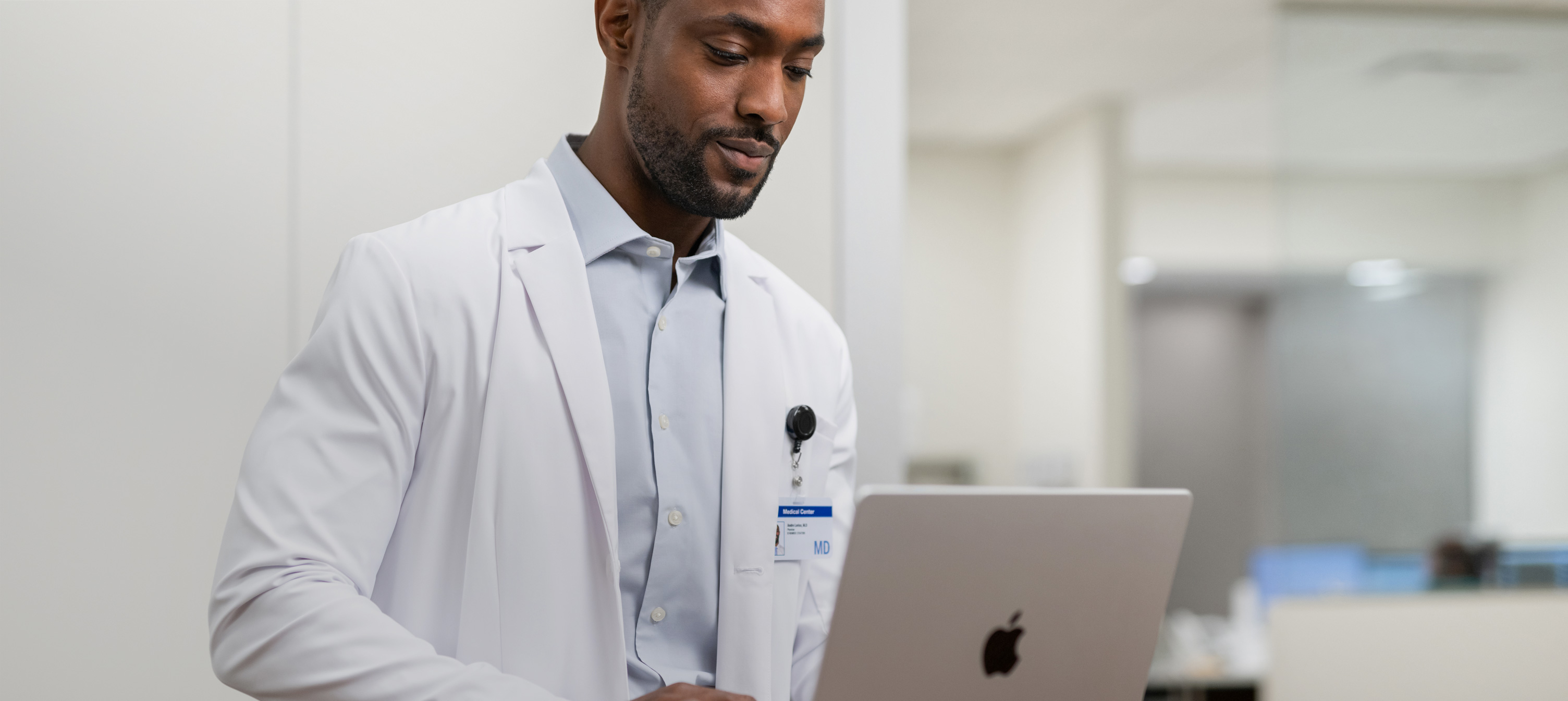 A doctor working on his MacBook Pro in the hospital.