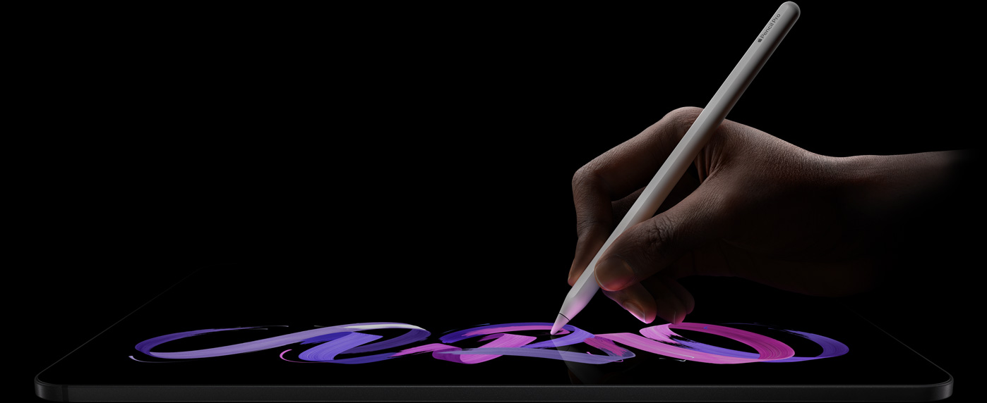 iPad Pro, pohľad spredu, orientácia na šírku, bočný profil, kozmická čierna farba, ruka drží Apple Pencil Pro, biela farba, na displeji kreslí abstraktné fialovoružové vzory