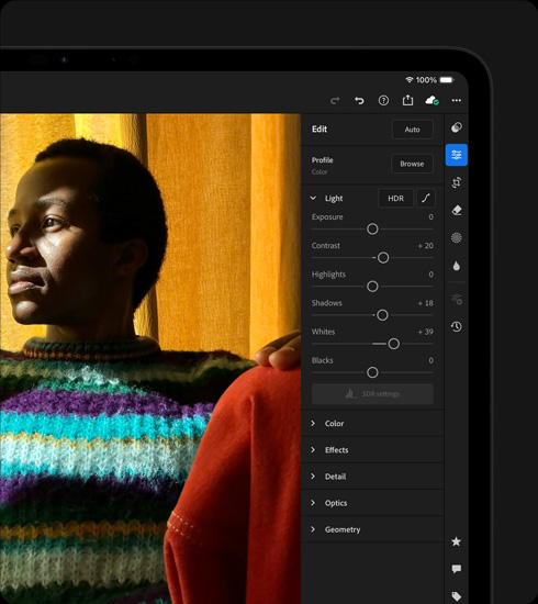 iPad Pro, pohľad spredu, orientácia na šírku, kozmická čierna farba, na displeji prebiehajú úpravy fotky osoby vo farebnom svetri, napravo je otvorené menu nástrojov a efektov