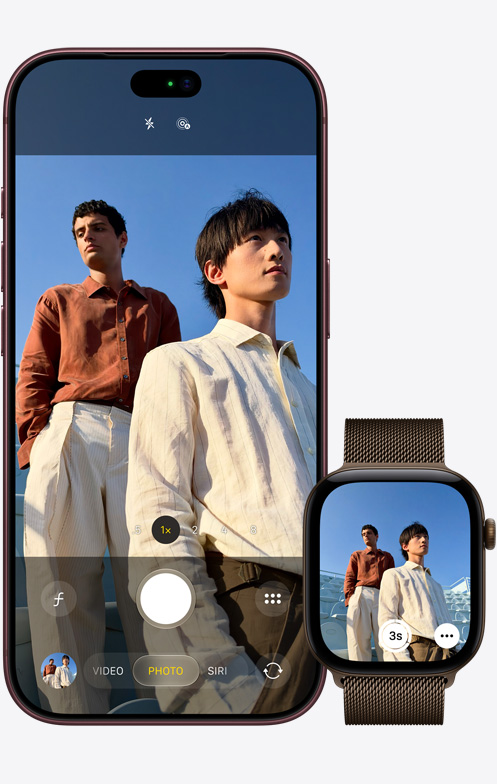 iPhone 18 Pro, exterior față, cameră în utilizare pentru a surprinde doi bărbați cu un cer albastru pe fundal, lângă Apple Watch Ultra 3 cu aplicația Telecomandă cameră deschisă