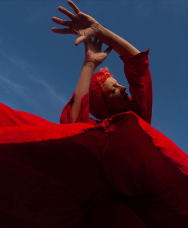Personne qui danse, vêtue d’une robe rouge